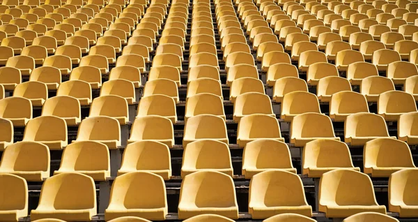 Tribünensitze im Sportstadion. Leere Freiluftarena. Konzept der Fans. Stühle für das Publikum. Kulturumweltkonzept. Farbe und Symmetrie. Leere Sitze. Modernes Stadion. Gelbe Tribünen — Stockfoto