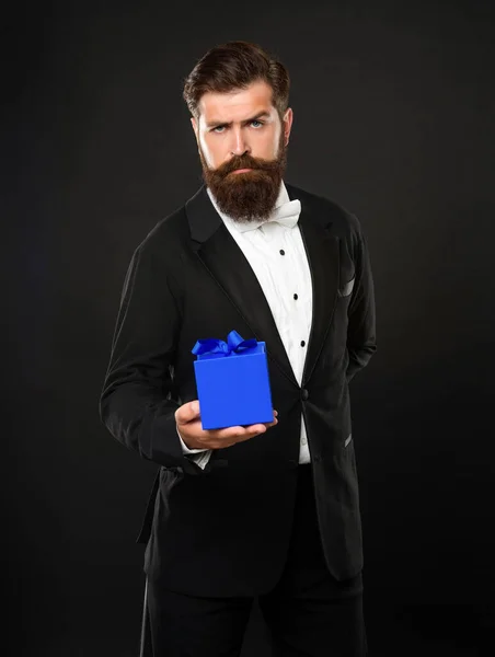 Seriózní muž ve smokingu motýlek formální oblečení na černém pozadí s krabicí. nákupní prodej — Stock fotografie