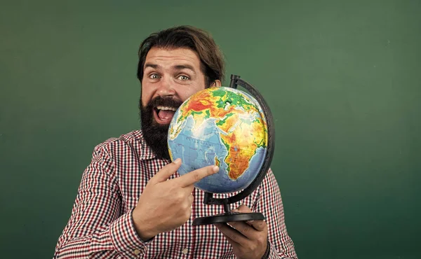 Χαρούμενα γενειοφόρος άνδρας με καρό πουκάμισο κρατώντας γεωγραφική σφαίρα, γεωγραφία σχολική εκπαίδευση — Φωτογραφία Αρχείου