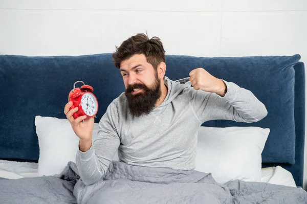 Angry man punching alarm clock being in bed in morning, overslept. —  Fotos de Stock