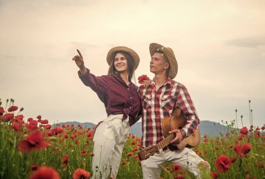 Hoş bir akşam. Gelincik çiçekli gitarlı romantik çift. Aile yaz tatili. Mutlu bir adam ve aşık bir kadın bahar havasının tadını çıkarırlar. Mutlu ilişkiler. Kız ve erkek sahada. müzik