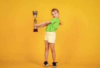 Büyük ilerleme. Mutlu yarışma kazananı. Gelmiş geçmiş en iyi ödül. Şampiyonluk kupasıyla gülümseyen çocuk. çocukluk mutluluğu. Spor giyim bölümünde güzel bir genç kız. Çocuk fitness şampiyonu. sağlıklı yaşam tarzı