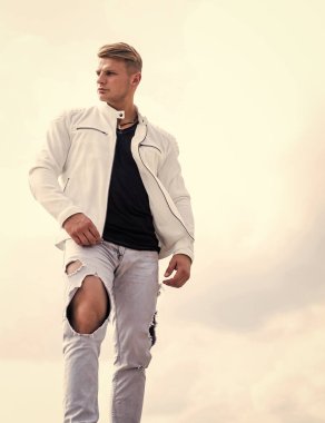 Sıradan giyinen bekar genç adam seyahat ediyor. Gökyüzü bulutlu, özgür.