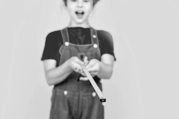 Щасливий інженер дитини зі стрічковим вимірювальним інструментом у жорсткому капелюсі, вимірювання, вибірковий фокус — стокове фото