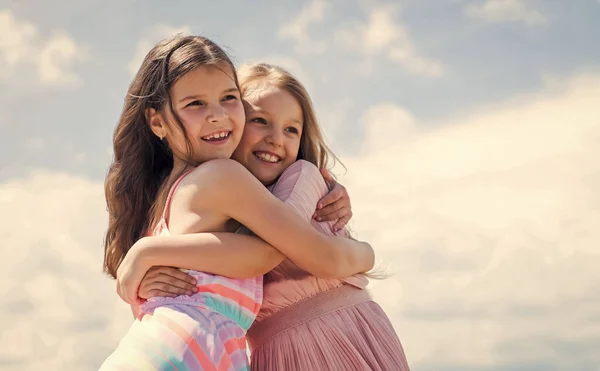 Niños felices abrazan en el fondo del cielo, amor familiar — Foto de Stock