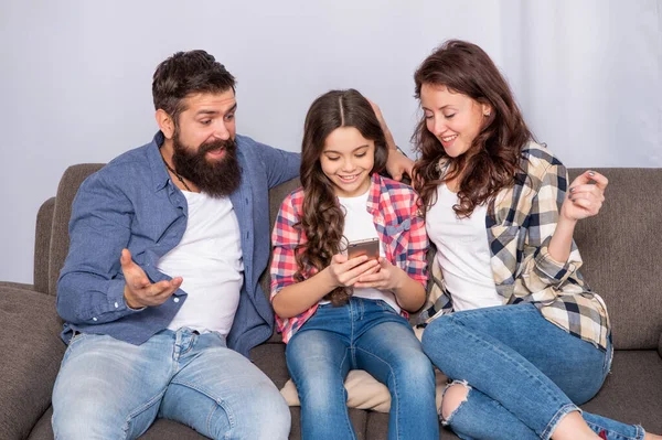 Van sms-em. Happy család olvas sms-t okostelefonon. SMS és üzenetküldés mobiltelefonon keresztül — Stock Fotó