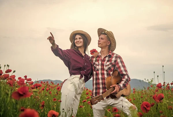 Hoş bir akşam. Gelincik çiçekli gitarlı romantik çift. Aile yaz tatili. Mutlu bir adam ve aşık bir kadın bahar havasının tadını çıkarırlar. Mutlu ilişkiler. Kız ve erkek sahada. müzik