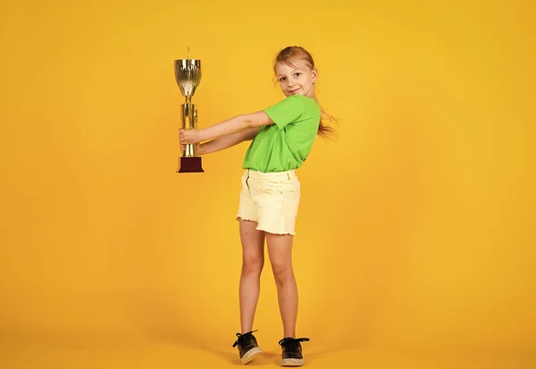 Grandi progressi. felice vincitore del concorso. la miglior ricompensa di sempre. bambino sorridente con coppa campionato. felicità infantile. bella ragazza adolescente in abbigliamento sportivo. campione di fitness per bambini. stile di vita sano — Foto Stock