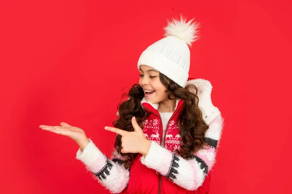 Presentazione dello spazio di copia. bambino stupito con i capelli ricci in gilet di Natale e cappello. giovanissima ragazza — Foto Stock