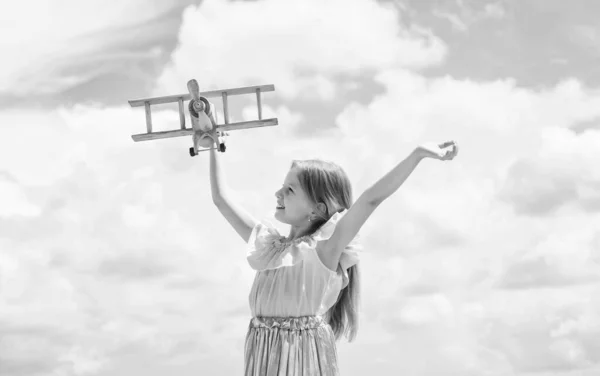 休暇旅行の準備ができている子供。飛びましょう。将来のキャリア。美しい10代の女の子が木製の飛行機で遊ぶ。子供のファッションスタイル。旅の概念です。幸せな子供時代。空の上の可愛い子 — ストック写真