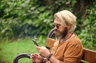 İstediğin yerde çalışabilirsin. İnternetten alışveriş. İnternette çalışıyorum. Hippi parkta ilham kaynağı oldu. Çevik iş. Sakallı adam park doğasında bankta oturuyor. Çalış ve rahatla. Temiz hava. Taşınabilir internet