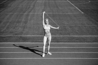 Zihnini boşalt. Antrenman ve antrenman. İp atlayan atletik bayan koç. Kadın spor eğitmeni. sağlıklı sportif yaşam tarzı. Sağlık ve enerji. Spor giyim bölümündeki kadın. Açık havada zıplamak