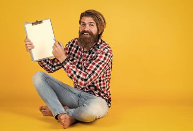 Kopyalama alanı için yer gösteriliyor. Kağıda bazı notlar yazıyorum. Hafta sonunu planlıyordu. Çok iş var. Güzel, yakışıklı bir emlakçı klasörü tutuyor ve pozitifliğini ifade ediyor. insanlar ve kurumsal konsept