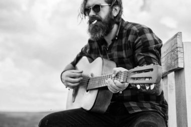Sakallı olgun hippi müzisyen. Gitar çalan vahşi beyaz adam. Country müziği. Sakallı adam şarkı söylüyor. Yakışıklı şarkıcı ve gitarist. Akustik gitarist. sigara tiryakisi
