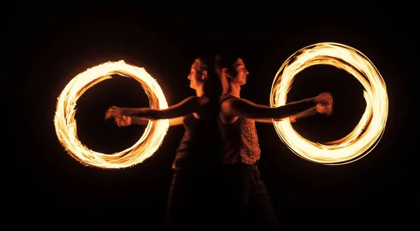 Creando impresionantes efectos de trazador. Un par de artistas realizan orbitales de fuego. Senderos de luz brillante y diseños. Desempeño. Burning Poi girando. Festival nocturno. Celebración festiva —  Fotos de Stock