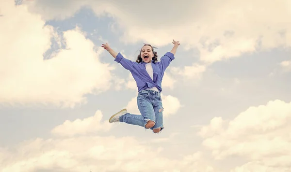 Веселый ребенок прыгать в повседневной джинсовой одежде на открытом воздухе, счастье — стоковое фото