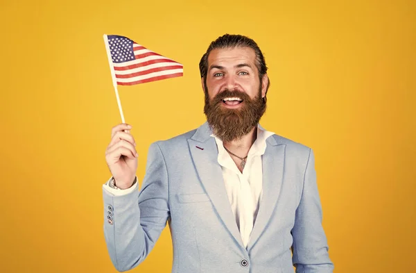 Работа и путешествия в США. День независимости. мужественность и харизма. формальный дресс-код. Политический бородатый парень держит американский флаг. концепция патриотизма. жестокий красивый мужчина с усами — стоковое фото