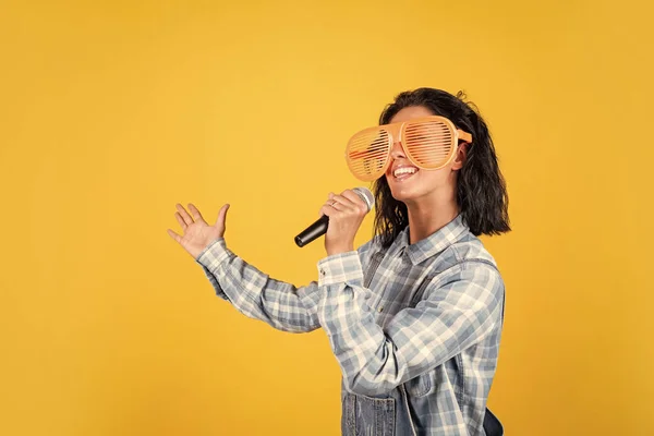 Mujer bonita feliz con pelo morena usar ropa casual cantar canción en el micrófono, karaoke —  Fotos de Stock