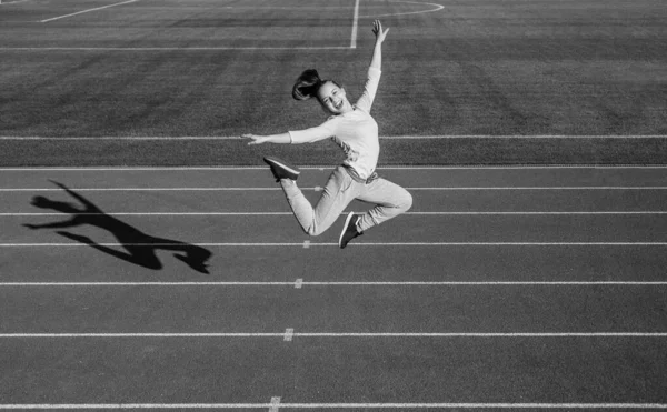 Energía dentro de ella. lleno de energía. entrenamiento al aire libre. confiado y libre. chica adolescente saltando en el estadio. Niño en ropa deportiva. niño hacer ejercicio en pista de carreras. infancia saludable — Foto de Stock