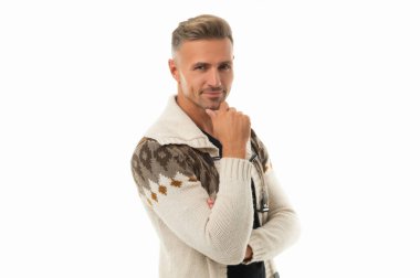 Mutlu yakışıklı, kendine güvenen, gülümseyen, sıradan bir hırkayla çenesini okşayan beyaz tenli adam.