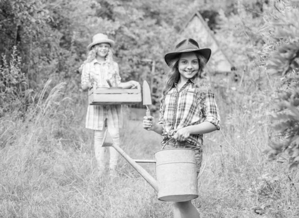 Loving nature. Cute gardener concept. Gardener occupation. Taking care of plants. Sisters helping at backyard. Girls with gardening tools. Child friendly garden tools ensure safety of child gardener — Stock Photo, Image