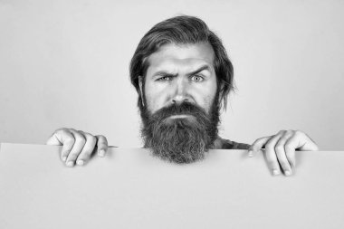 Kendine güven. bir iş arıyorum. Kopyalama alanı için yer. Boş kâğıt kağıtları olan ciddi sakallı bir adam. Berber dükkanı servisi. Reklam konsepti. Sakallı ve bıyıklı vahşi adam.