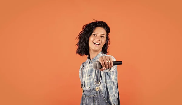 Souriant hipster femelle avec des vêtements à la mode chanter dans le microphone, la musique — Photo