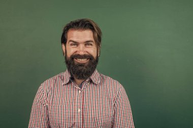 Sakallı ve bıyıklı gülümseyen bir adam üniversitede ya da okulda iş adamı ya da öğretmen gibi görünüyor, insani duygular.