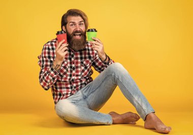 Günaydın. Enerjik, sıcak içecek. İlham almak için kahve lazım. Mutlu sakallı adam sabah kahvesini içiyor. Adam kağıt bardaktan sıcak çay içiyor. Boşluğu kopyala