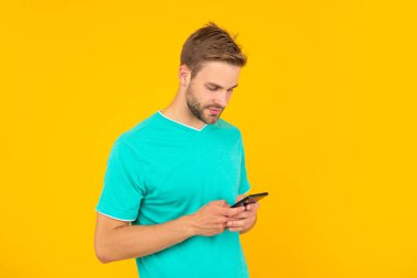 guy with bristle chatting on smartphone on yellow background, technology