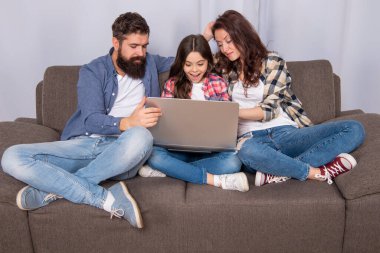 parents with amazed kid use pc at home, shopping