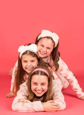 Pajama party is a real laugh. Happy sisters laughing lying close on each other. Laugh and be happy