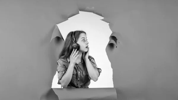 Dospívající dívka poslouchající hudbu ve sluchátkách. Šťastné dětství. hezké dítě na pozadí studia. — Stock fotografie