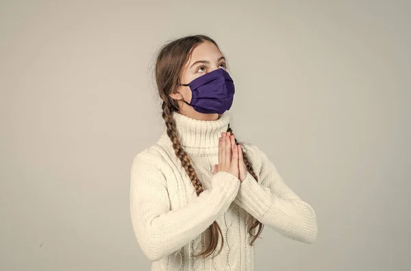 Lány gyermek visel légzőkészülék maszkot, hogy megvédje a koronavírus, imádkozz — Stock Fotó