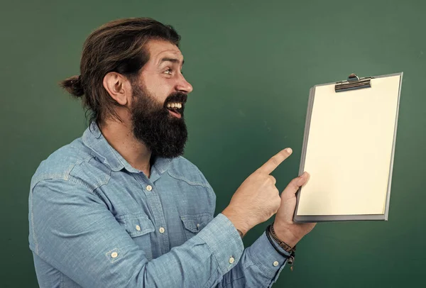 Good looking hipster with beard and moustache showing document paper for making notes, copy space, ad — Stockfoto