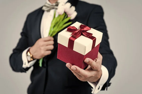 Compra las tiendas para ideas de regalos. Caja de regalo en manos masculinas. Tienda de regalos. Arreglo floral. Celebración festiva. Ocasión festiva — Foto de Stock