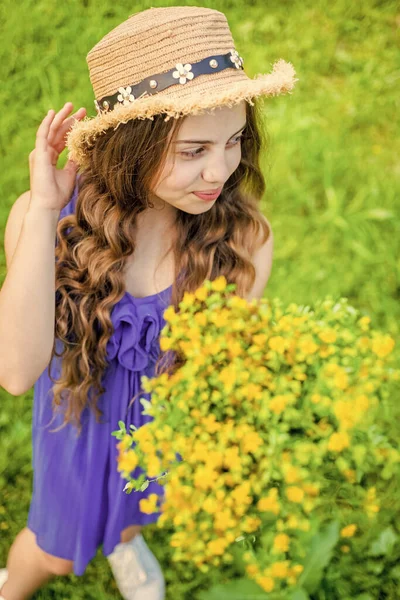 Lycklig flicka bär halm hatt skörda blommande örter i fält — Stockfoto