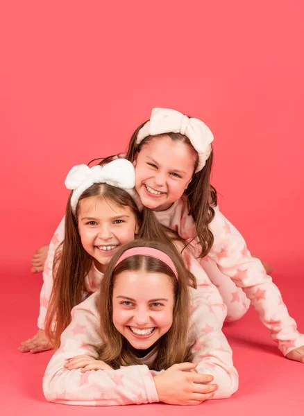 Pajama party is a real laugh. Happy sisters laughing lying close on each other. Laugh and be happy — Zdjęcie stockowe