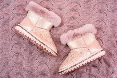 pair of fashionable leather ugg boots. ankle boots on knitted background. shoe store