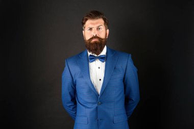 serious man in tuxedo bow tie. gentleman in formalwear on black background. male formal fashion