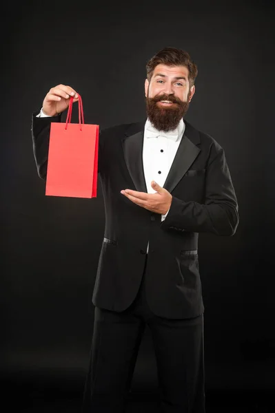 ショッピングバッグにビジネスの報酬を提示タキシード蝶ネクタイの幸せな男。ごあいさつだ。コピースペース — ストック写真