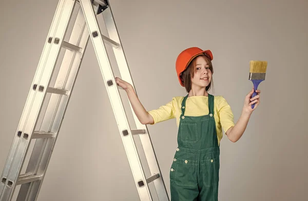 10代の女の子の労働者保護ヘルメットと塗装ブラシ、改装とはしごの制服 — ストック写真