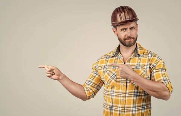 Kijk daar eens. Volwassen bouwer in hemd. Ongeschoren man op de bouwplaats. Een knappe bouwvakker met een hoed. Arbeidsdag. Hij draagt een veiligheidshelm met wijzende vinger. ingenieur op het werk. mannelijke levensstijl — Stockfoto