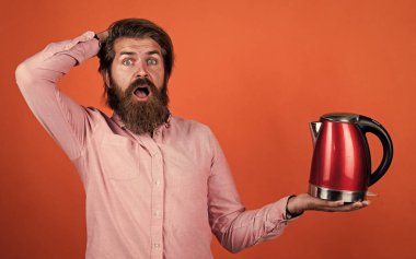 Tişörtünde sakal olan vahşi beyaz hippi elektrikli su ısıtıcısı, teknoloji.