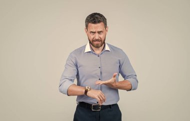 Tişörtlü yakışıklı, sakallı iş adamı, saati gösteriyor, vakit yok.