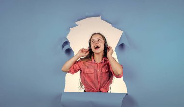 Ne güzel bir gün. Dijital çağda yaşamak. Genç çocuk müzik dinler. Çocuk dinleme kitabı. Elderning kavramı. Modern cihazlarla çevrimiçi eğitim. Kız kulaklık takıyor. iyi kalite ses