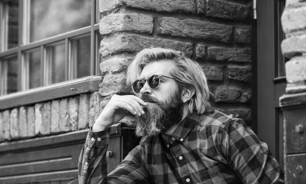 Brutal male with blond hair irish architecture background. Man casual fashion. Cool guy. Bearded man checkered shirt. Hipster dyed hair and beard. Hairdresser and barbershop. Hipster in sunglasses — Stock Photo, Image