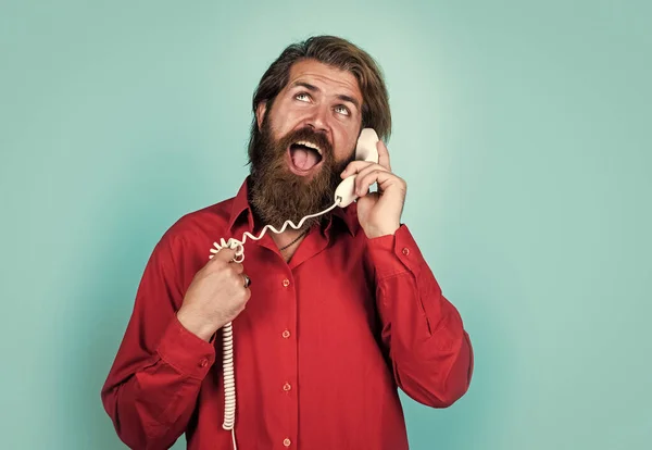Concepto de comunicación. El hombre barbudo de camisa llama por teléfono. chico casual durante la conversación. hipster emocional con pelo largo y bigote. macho hablando por teléfono retro — Foto de Stock
