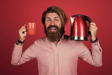 Günaydın. Gününü ısıt. Sakallı adam. Sıcak içecek iç. Mutfak gereçlerini sunuyorum. İyi kalite. Sakallı, çay içen olgun bir hippi. Elektrikli su ısıtıcısı olan vahşi adam.