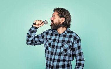 Duygusal, vahşi bir adam karaoke 'de mikrofonla şarkı söylüyor.